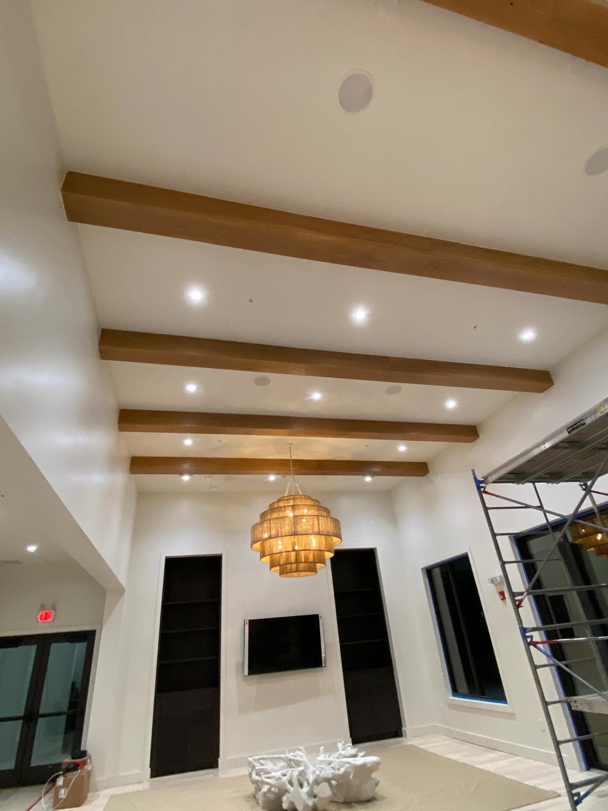 Luxury estate room with exposed wood ceiling beams and woven chandelier by Benito Fine Carpentry Palm Beach County